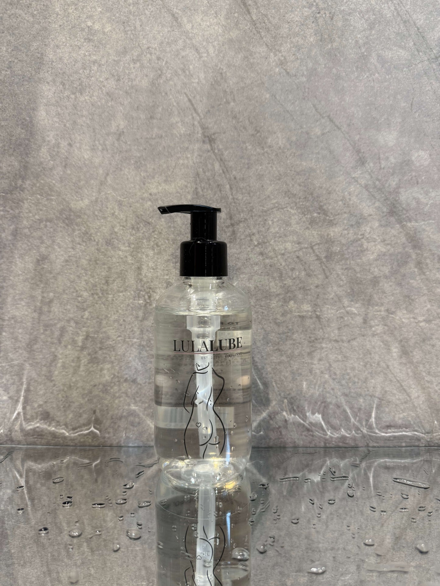 bottle of water based lubricant on a refelctive surface ready for anal